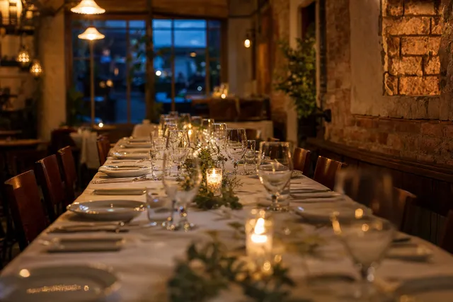 A long table laid with candles and glasses for a birthday dinner.